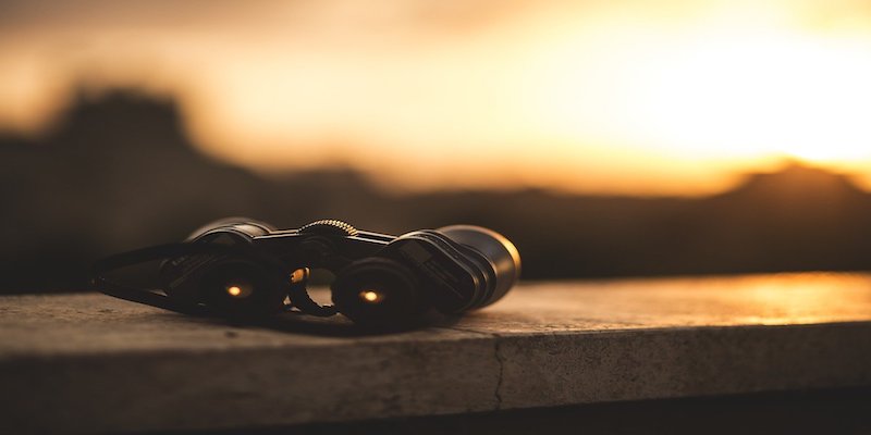 binoculars against sunset backdrop