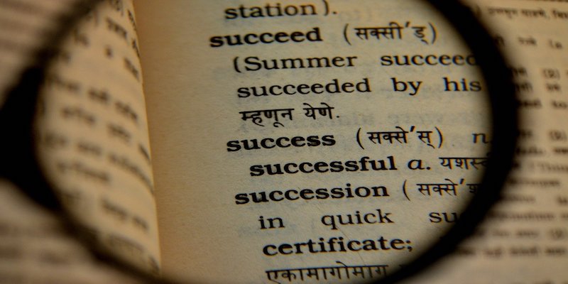 magnifying glass over the word success in dictionary