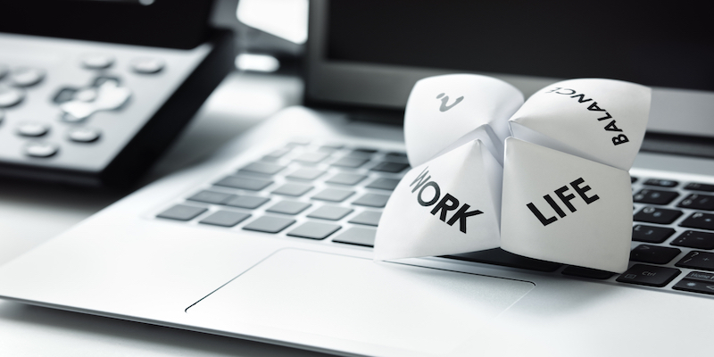 Origami fortune teller on laptop in office concept for work life balance choices